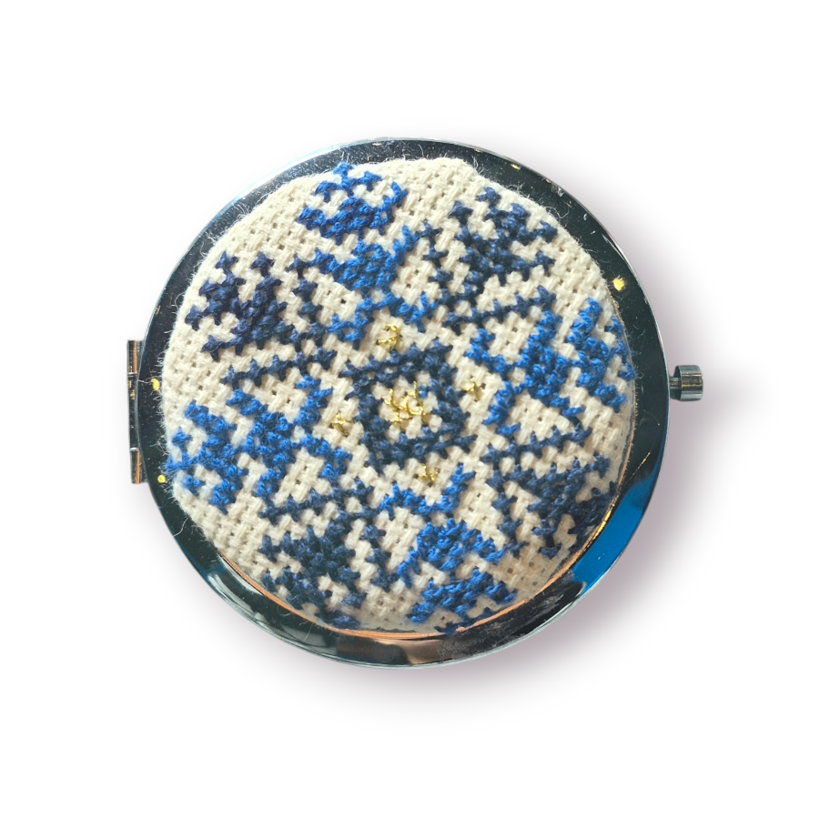 Compact mirror with blue floral pattern on a white background
